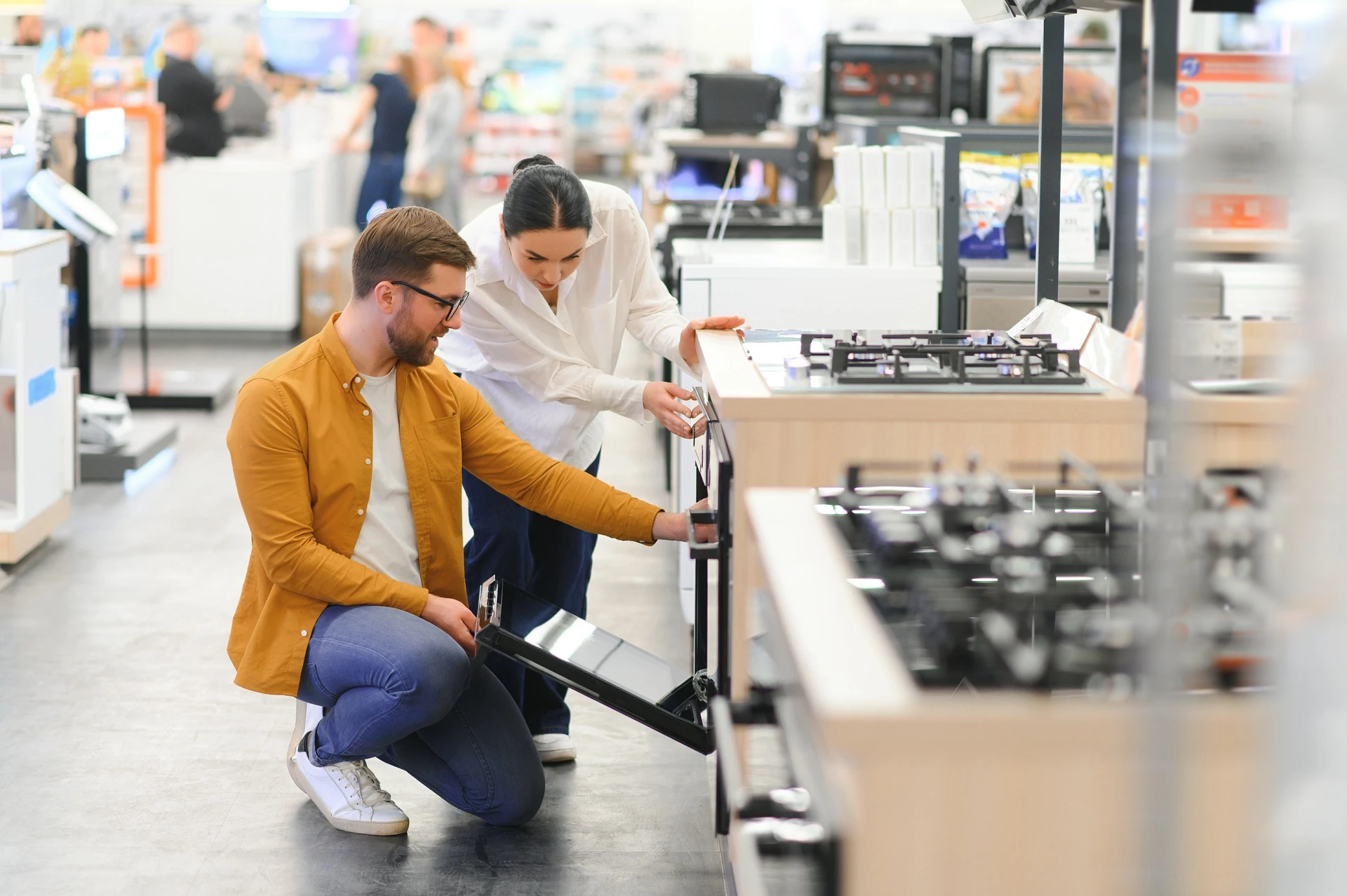 Young man and woman buying gas stove in manasota goodwill appliances store