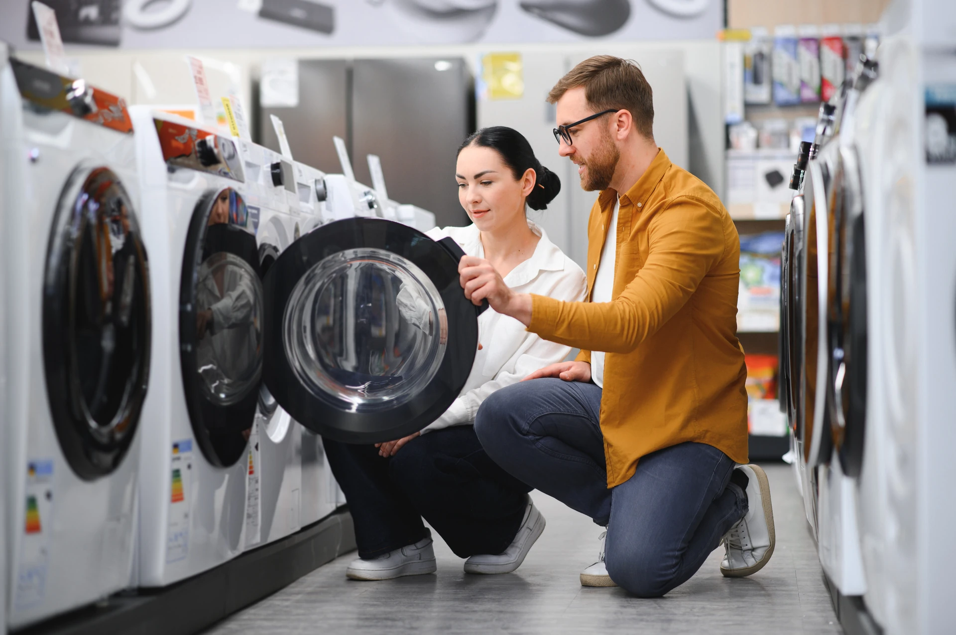 couple choosing washing machine at goodwill appliances store