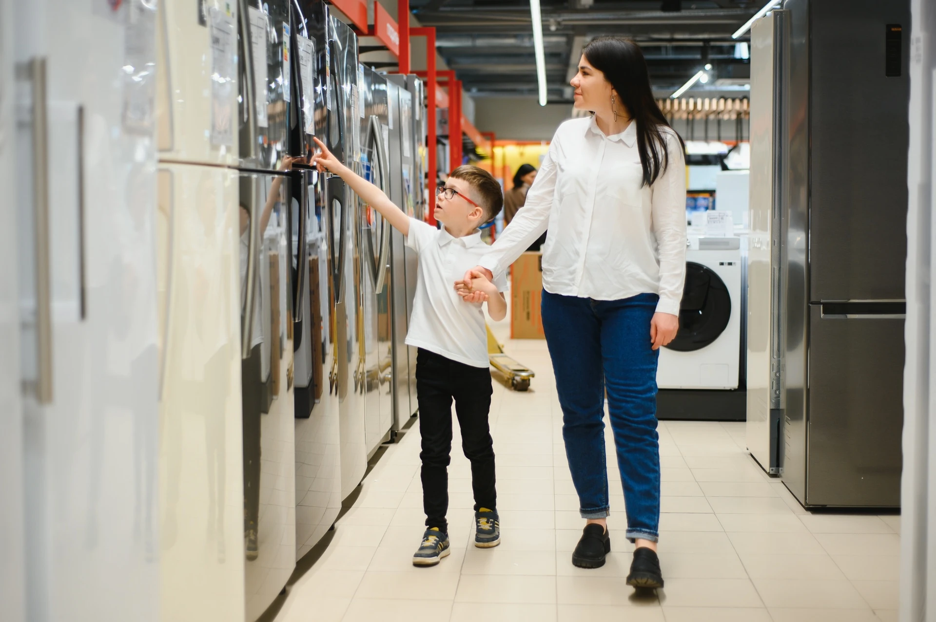 mother with son choosing refrigerator at store in goodwill manasota