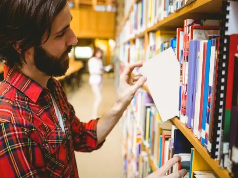shoppers browsing Goodwill books in Boynton Beach among thrift store books on tall store shelves