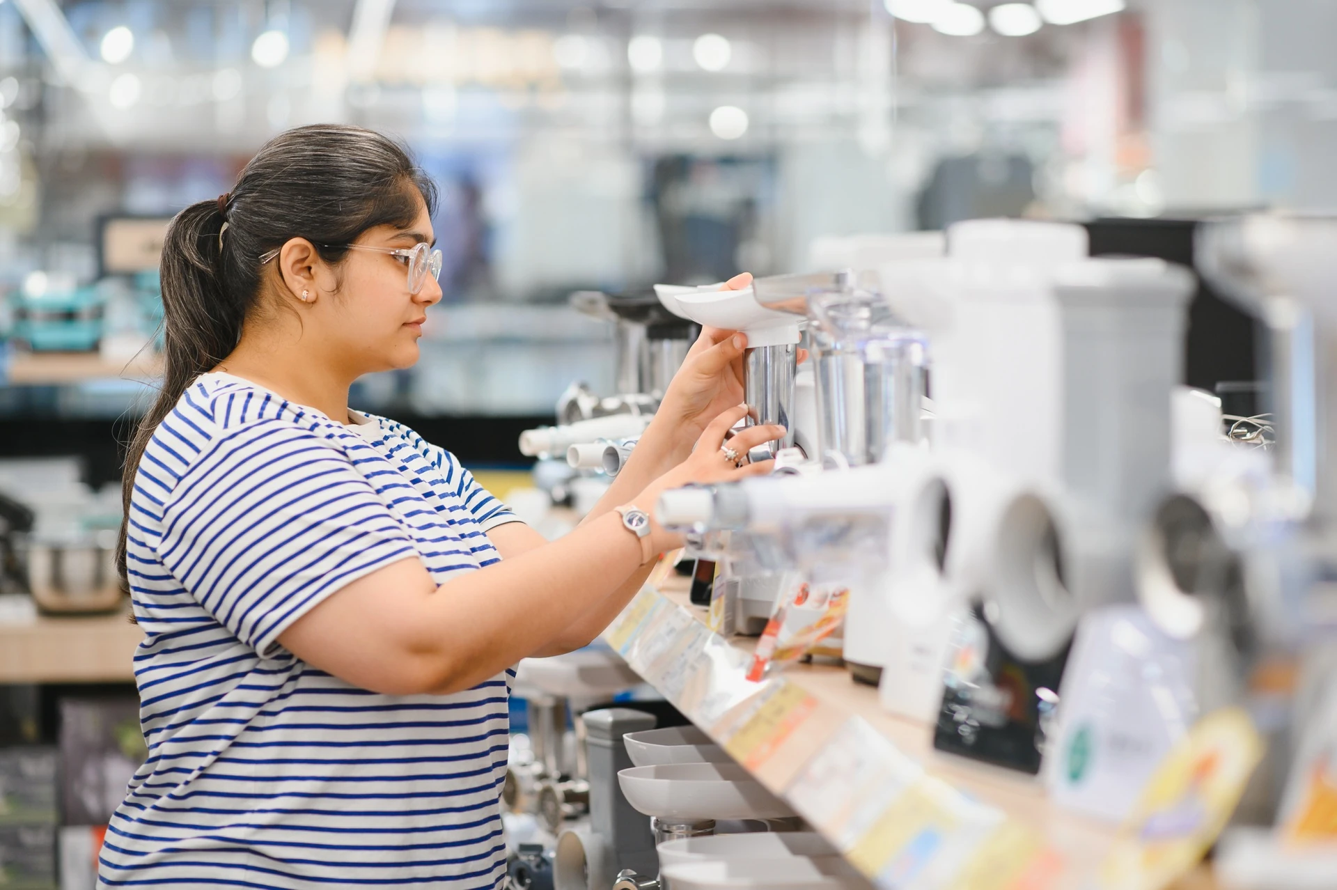 woman choosing kitchen mixer blender in home appliances goodwill store in bradenton