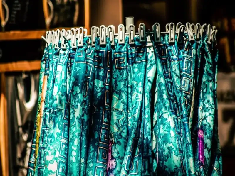 close-up of colorful used clothing pieces on hangers arranged by size in a bradenton store