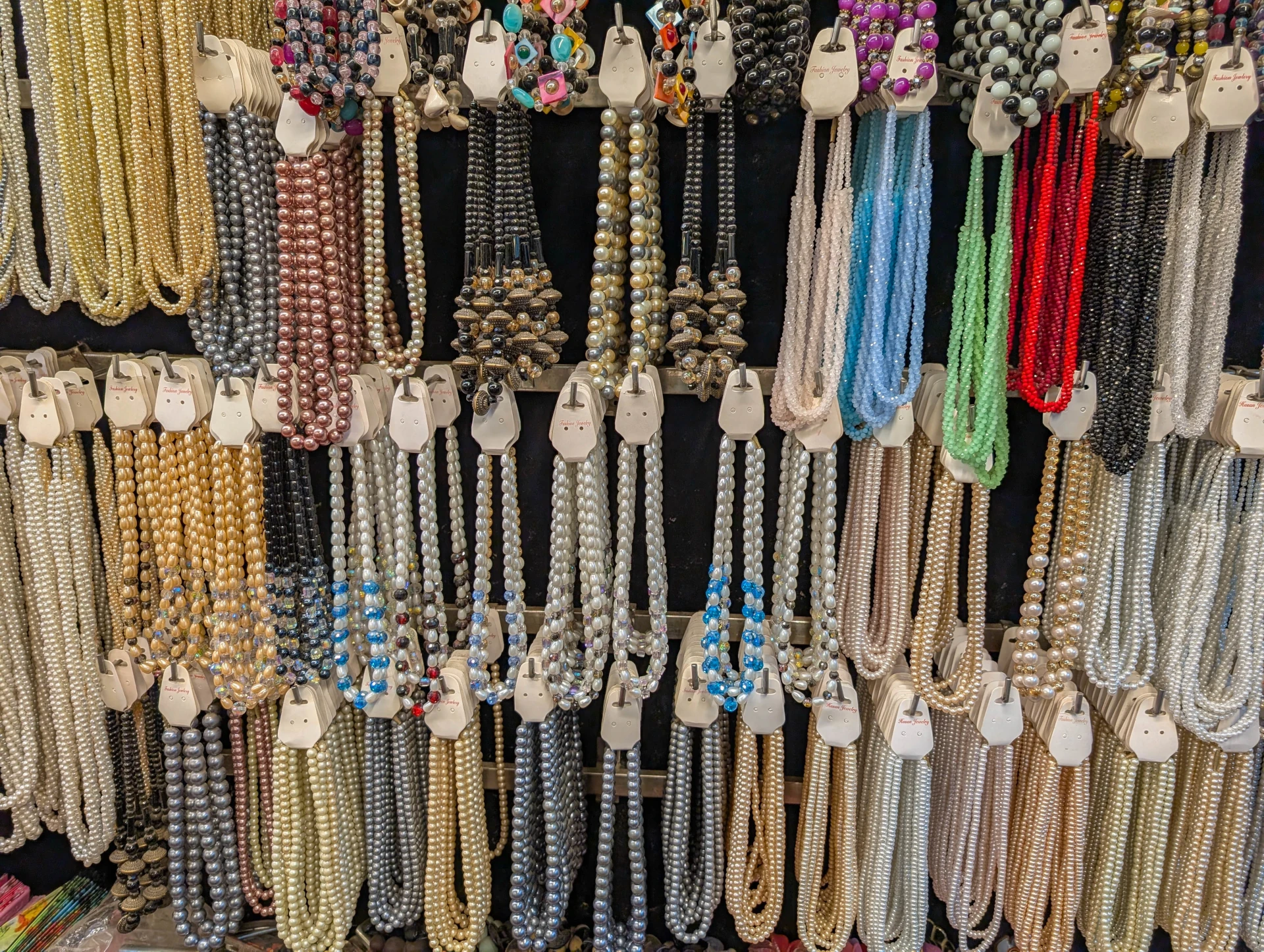 collection of chains and necklaces labeled as used jewelry for sale at the boynton beach store