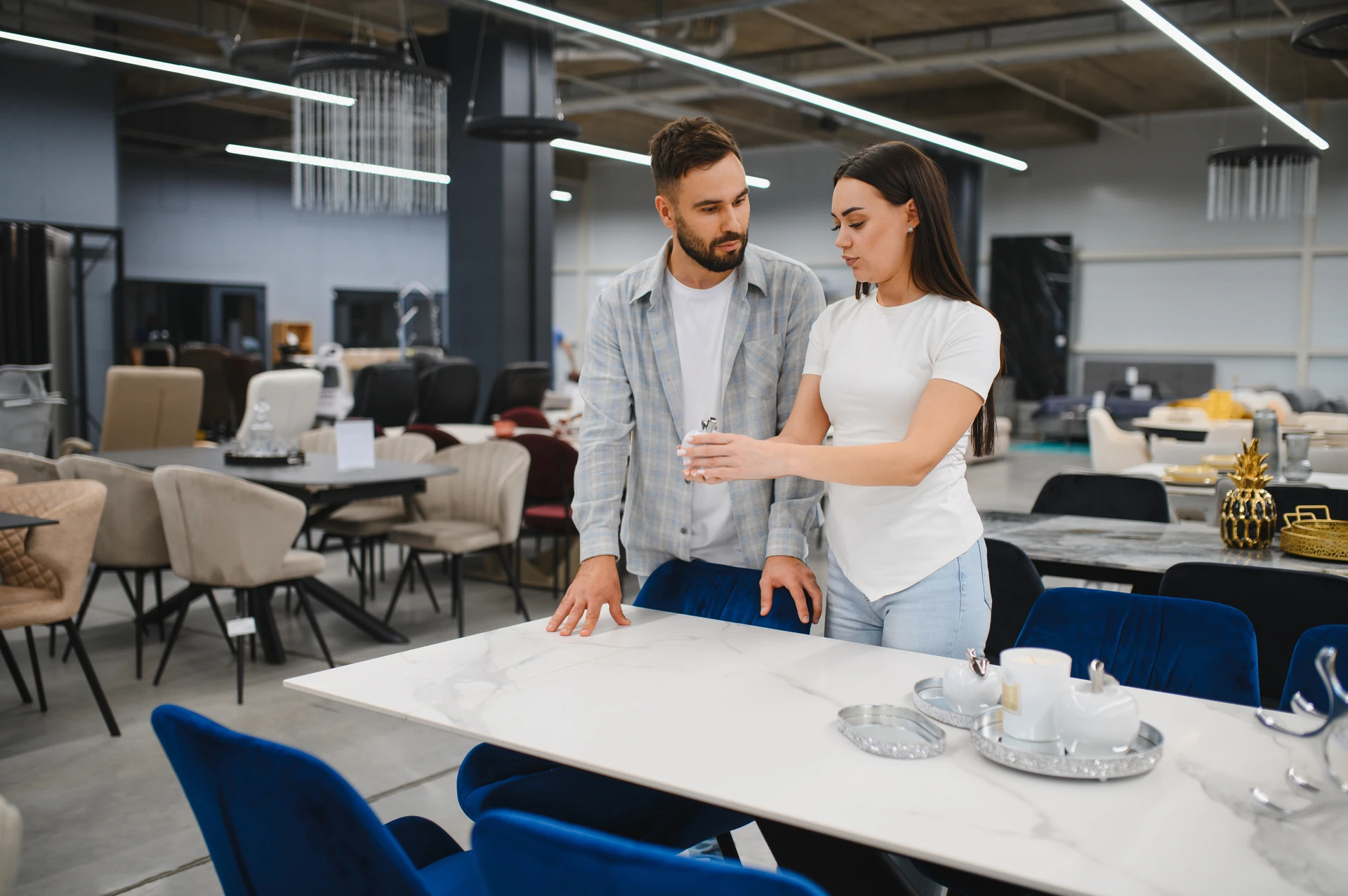 couple choosing furniture pieces from a large display inside a second hand furniture store