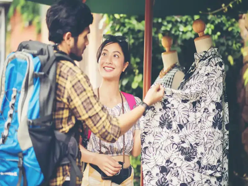 customers exploring tops and jackets sorted by size and color inside a used clothing store in bradenton
