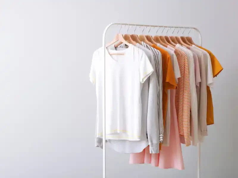 mixed styles of sustainable fashion garments hung in a used clothing store