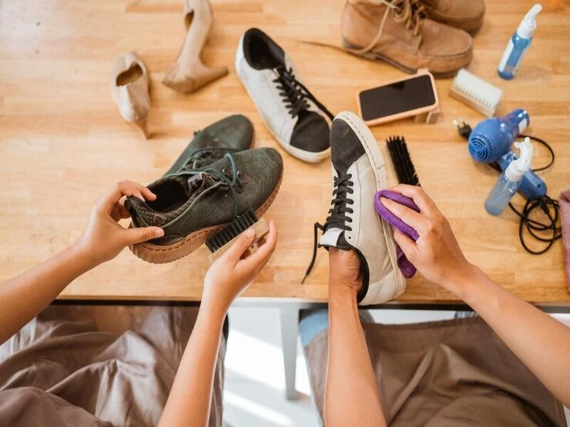 people cleaning shoes to display at thrift store