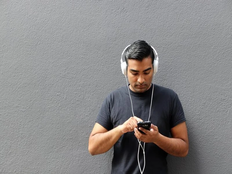 shopper testing secondhand headphones inside a goodwill computer store electronics section