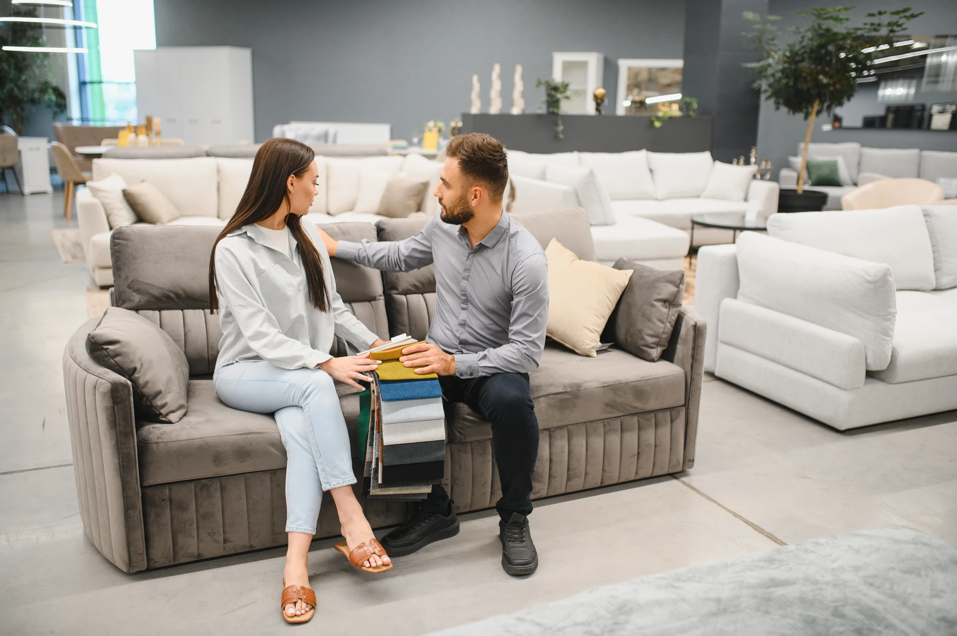 woman choosing sofa color from sample at used furniture store